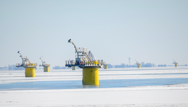 Foundations for the Fryslan offshore wind farm sit in the frozen IJsselemeer lake in the Netherlands awaiting turbine installation in the Spring