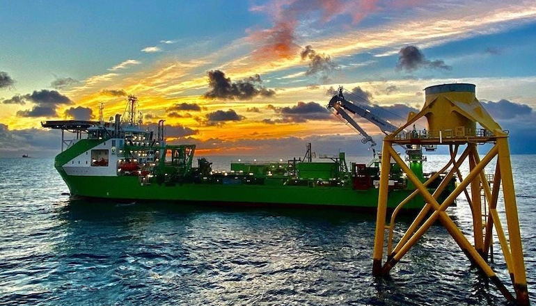 The sun sets on DEME Offshore's cable installation vessel Living Stone while at work installing 102 array cables on the 950MW Moray East offshore wind farm in Scotland